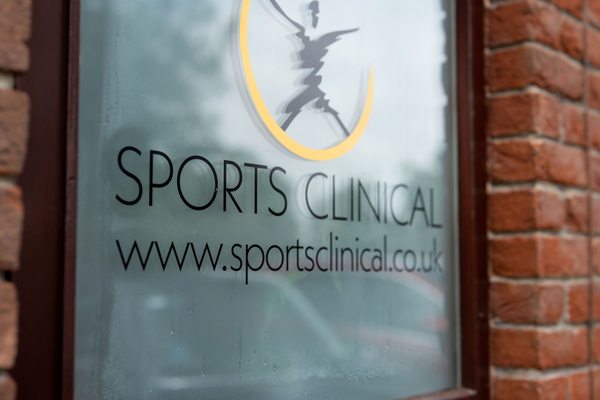 The SPORTS CLINICAL window signage at the Bassingham clinic, etched wordmark and web address on frosted glass