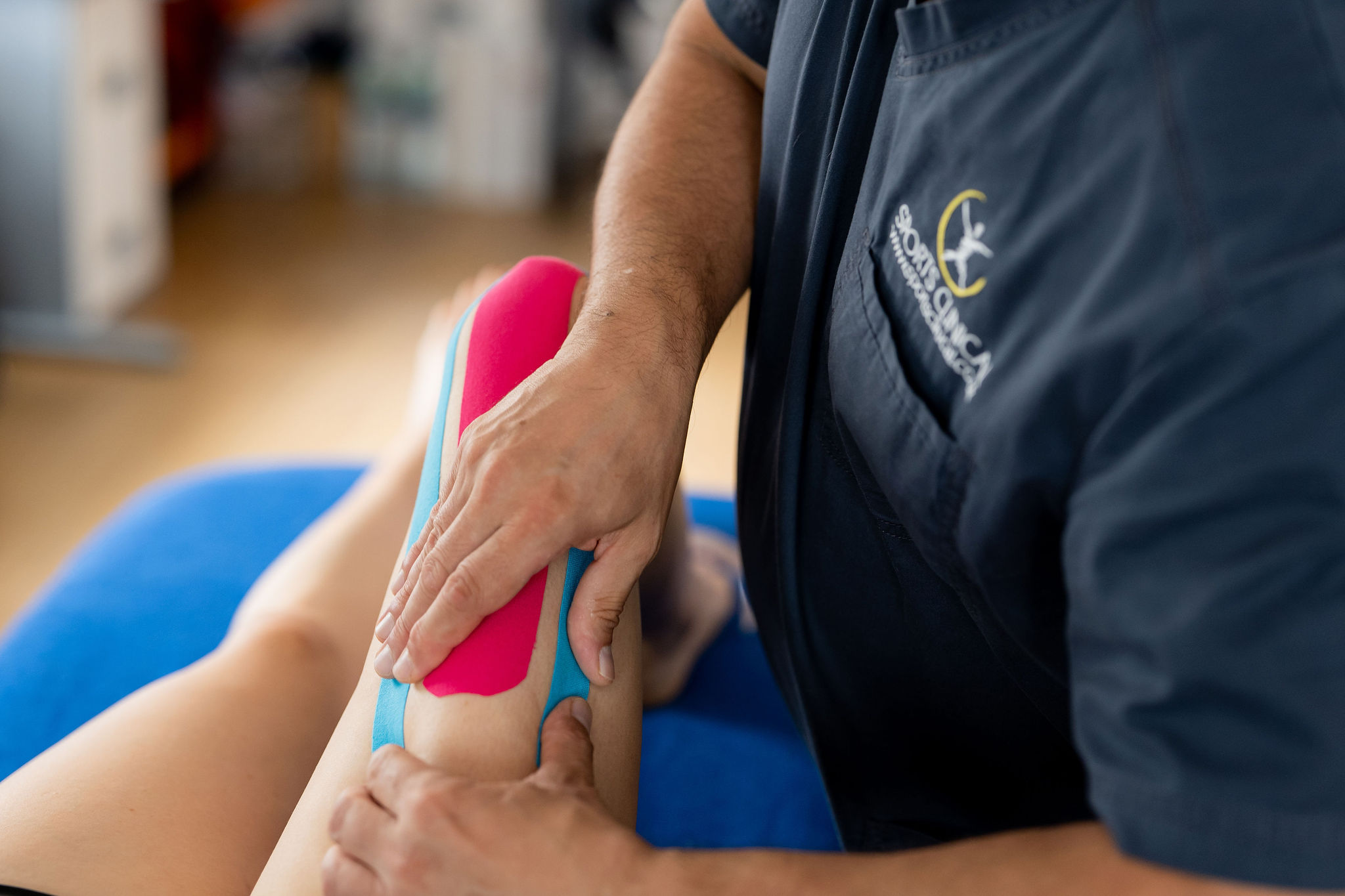 Kinesiology taping of a knee injury at SPORTS CLINICAL